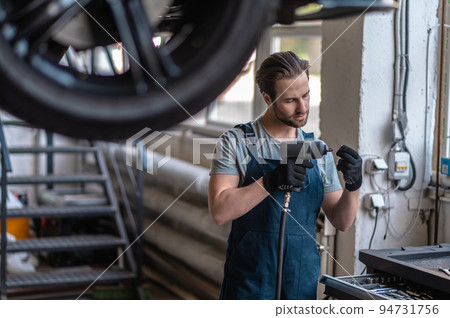 Service man working in the car repair shop Service man working in the car repair shop 94731756