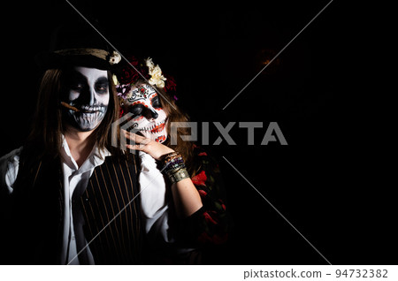 Woman in santa muerte costume and man in skeleton bodypainting for halloween. Woman in santa muerte costume and man in skeleton bodypainting for halloween. 94732382