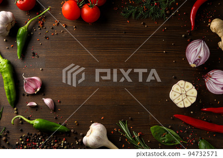Different cooking ingredients and spices on wooden background Different cooking ingredients and spices on wooden background 94732571