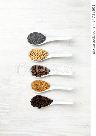 Spoons with different food on white wooden background Spoons with different food on white wooden background 94732601