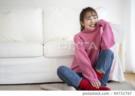 穿著粉色毛衣的微笑年輕女子 94732787