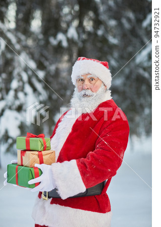 Santa Claus Holding Gifts Outdoors Santa Claus Holding Gifts Outdoors 94732921