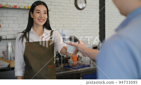 Coffee shop concept of 4k Resolution. The barista is delivering coffee mugs to customers in the shop. 94733095