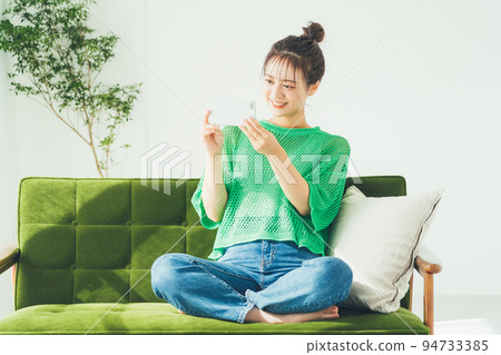 Woman watching video on smartphone Woman watching video on smartphone 94733385