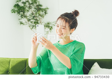 坐沙發和看智能手機的婦女 94733430