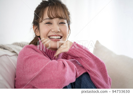 smiling young woman in pink sweater 94733630