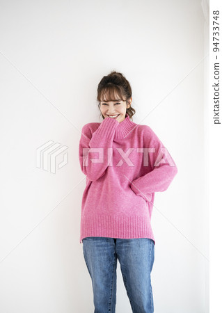 穿著粉色毛衣的微笑年輕女子 穿著粉色毛衣的微笑年輕女子 94733748