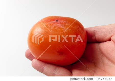 Ripe persimmon on a white background Ripe persimmon on a white background 94734052