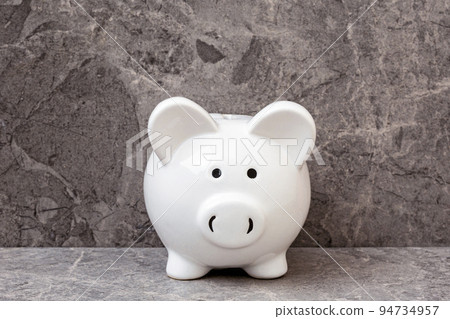 White piggy bank on a grey stone background 94734957