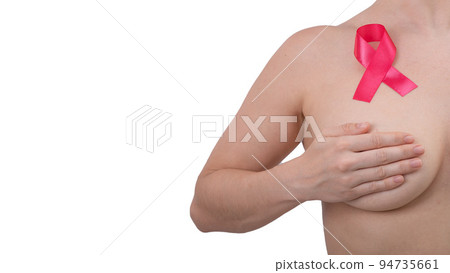 Caucasian woman covers her chest with her hands on a white background. The pink ribbon symbolizes the fight against breast cancer. Caucasian woman covers her chest with her hands on a white background. The pink ribbon symbolizes the fight against breast cancer. 94735661