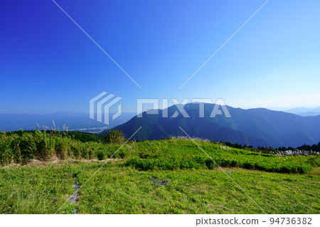 Japanese pampas grass field and bamboo grass field in Katsuragi Kogen with Mt. Kongo in the background 94736382