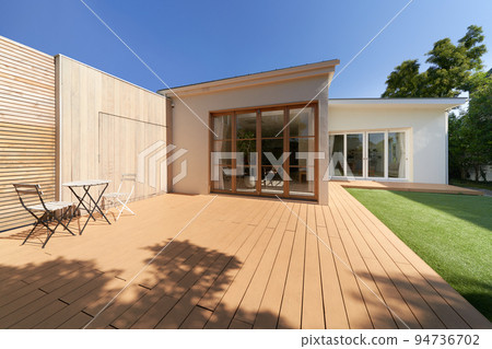 Designer house with wooden deck and lawn exterior image 94736702