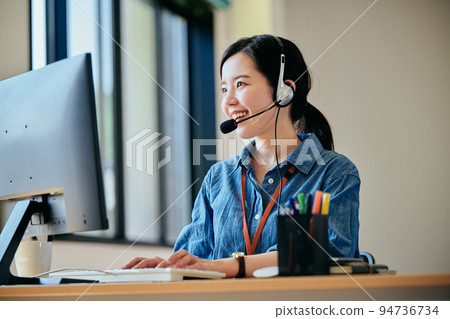 在辦公室接電話的年輕女人 94736734