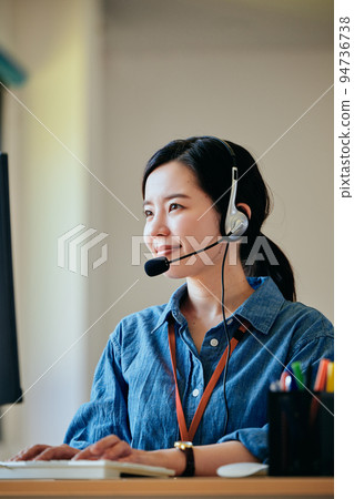 在辦公室接電話的年輕女人 94736738