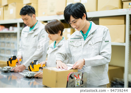 Young male staff doing packing work in the backyard Young male staff doing packing work in the backyard 94739244