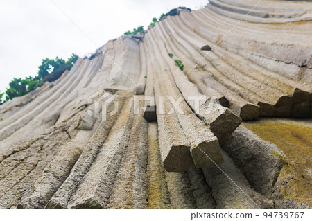 basalt columns forming a coastal rock at Cape Stolbchaty on Kunashir Island, close-up basalt columns forming a coastal rock at Cape Stolbchaty on Kunashir Island, close-up 94739767