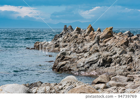 sharp jagged basalt rocks on the sea coast 94739769