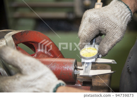 Close up scene the operator measuring inside diameter casting parts by dial Vernier caliper. 94739873
