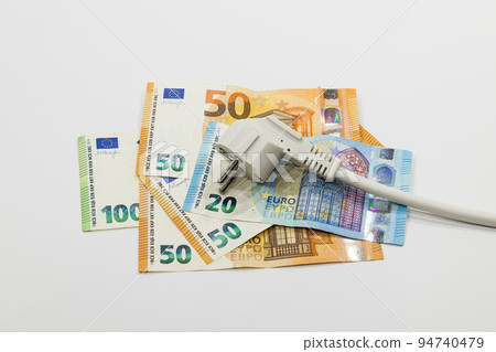 The electric power plug on Euro banknotes. Concept of expensive electricity costs 94740479