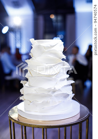 Multilevel wedding cake on a metal table Multilevel wedding cake on a metal table 94740574