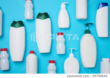 Empty plastic white bottles for cosmetics and other liquid substances on a blue background. Blank for branding gel, shampoo, detergent 94740688