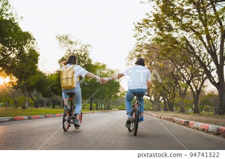 spring is comming concept with happy and cheerful feeling of asian couple riding bicycle together 94741322