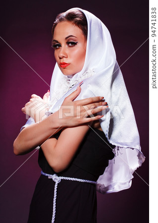 Nice girl dressed as a nun on a black background Nice girl dressed as a nun on a black background 94741838