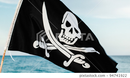Black pirate flag with skull symbol on the desert island Black pirate flag with skull symbol on the desert island 94741922