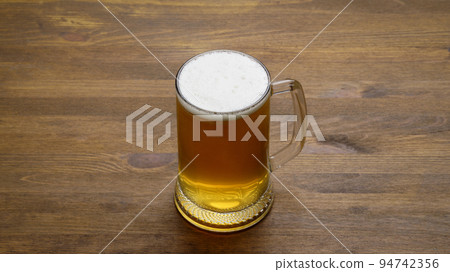 large mug of light tasty cold beer on a wooden table large mug of light tasty cold beer on a wooden table 94742356
