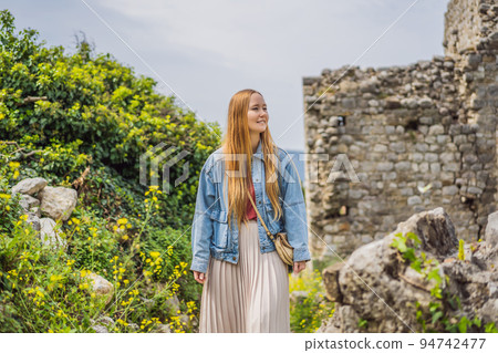 Woman tourist walks through the old town of Bar in Montenegro. Happy tourist walks in the mountains. Suburbs of the city of Bar, Montenegro, Balkans. Beautiful nature and landscape Woman tourist walks through the old town of Bar in Montenegro. Happy tourist walks in the mountains. Suburbs of the city of Bar, Montenegro, Balkans. Beautiful nature and landscape 94742477
