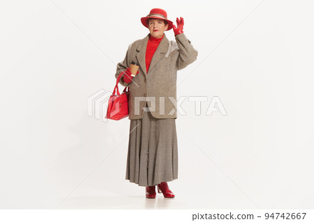 Portrait of beautiful senior woman in retro vintage style outfit posing isolated on white background. Concept of beauty, old generation, fashion, emotions 94742667