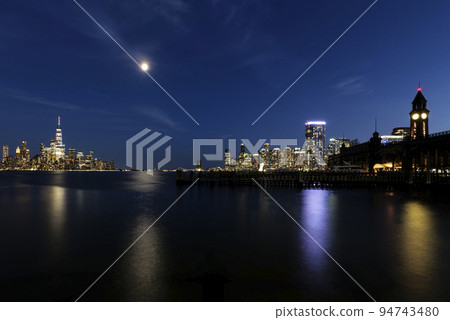 View of Hoboken, NJ Transit Terminal, and skyline of Manhattan at night 94743480