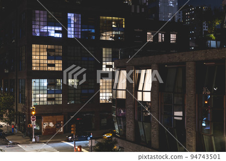 Modern office building at night with light in windows, New York City 94743501