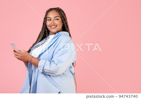 African Lady Using Cellphone Looking At Free Space, Pink Background African Lady Using Cellphone Looking At Free Space, Pink Background 94743740