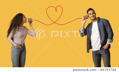 Woman Sending Love Message To Boyfriend Through Phone With Heart Shaped String Woman Sending Love Message To Boyfriend Through Phone With Heart Shaped String 94743788