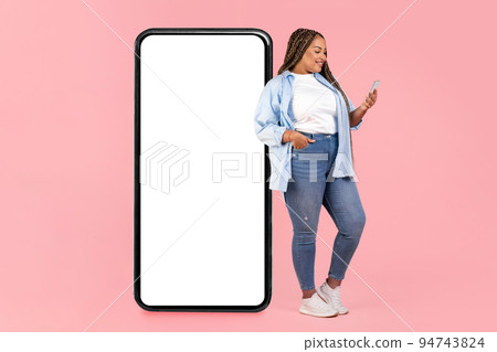 African Lady Leaning On Big Phone Texting Over Pink Background African Lady Leaning On Big Phone Texting Over Pink Background 94743824