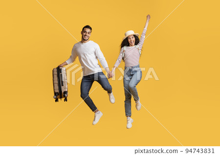 Crazy Offer. Overjoyed Arab Couple Holding Hands And Jumping With Suitcase Crazy Offer. Overjoyed Arab Couple Holding Hands And Jumping With Suitcase 94743831
