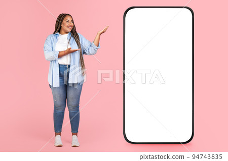 Black Lady Showing Huge Smartphone With Empty Screen, Pink Background Black Lady Showing Huge Smartphone With Empty Screen, Pink Background 94743835