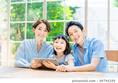 A family watching over an elementary school girl studying A family watching over an elementary school girl studying 94744289