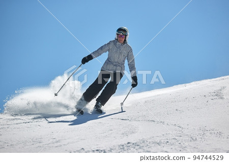 Skiing in the winter snowy slopes Skiing in the winter snowy slopes 94744529
