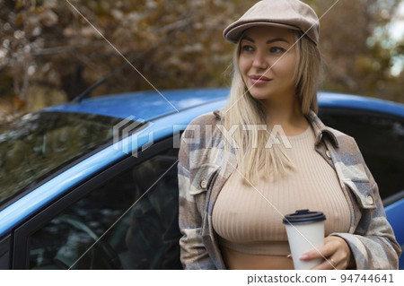 Sexy girl poses outside the car in autumn in fashionable clothes 94744641