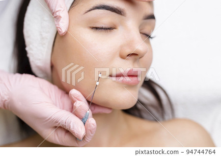 Face lifting PDO Suture operation. innovative technique of New thread lift, cosmetologist preparing to do procedure to female client, select the appropriate thread option 94744764