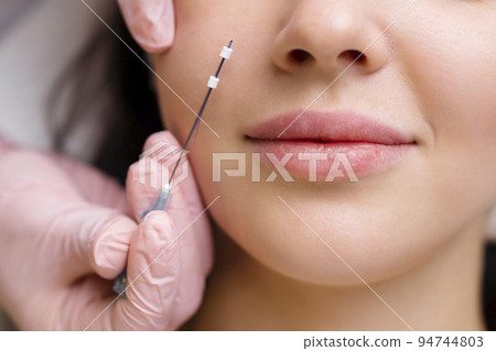 Face lifting PDO Suture operation. innovative technique of New thread lift, cosmetologist preparing to do procedure to female client, select the appropriate thread option Face lifting PDO Suture operation. innovative technique of New thread lift, cosmetologist preparing to do procedure to female client, select the appropriate thread option 94744803