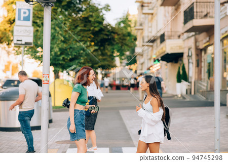 Happy women talking and laughing at the city street Happy women talking and laughing at the city street 94745298