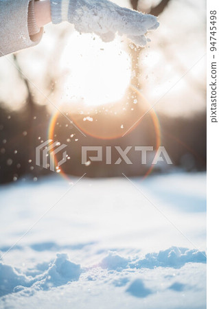A woman holding snow in the backlight A woman holding snow in the backlight 94745498