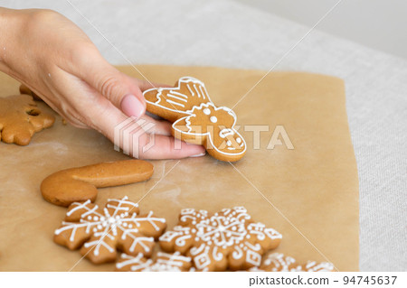 Christmas shortbread man. Women's hands hold a traditional New Year's gingerbread man Christmas shortbread man. Women's hands hold a traditional New Year's gingerbread man 94745637