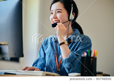 Young woman answering the phone in the office Young woman answering the phone in the office 94746600