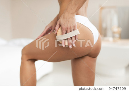 Unrecognizable middle aged woman making anti cellulite or lymphatic thigh massage on hips, closeup 94747209