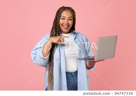 African American Woman Using Laptop Pointing At Computer, Pink Background African American Woman Using Laptop Pointing At Computer, Pink Background 94747339