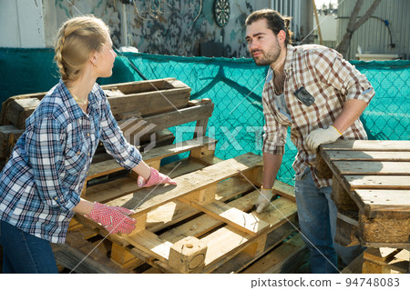 Couple working with wooden pallets 94748083